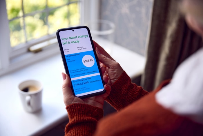 Femme regardant sa facture d'énergie sur son téléphone