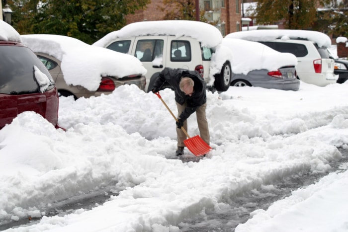 farmers almanac winter forecast - homme pelletant la neige près de voitures enterrées