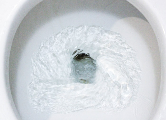 A toilet bowl being flushed.