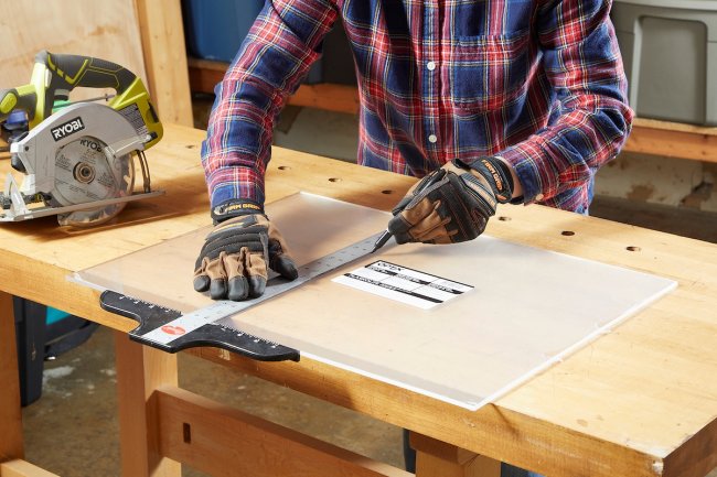 Personne utilisant une règle en métal sur du plexiglas épais.