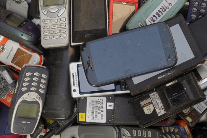 Un tas de vieux téléphones portables, de smartphones cassés et de téléphones portables vintage dans une brocante.