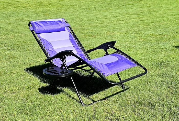 Chaise violette à gravité zéro allongée sur l'herbe