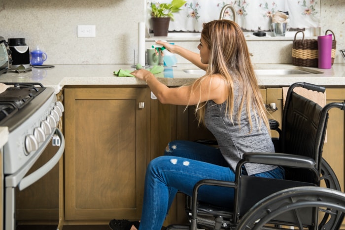 novembre must dos femme en fauteuil roulant nettoyant la cuisine