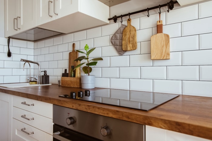 Un dosseret de cuisine avec des carreaux de faïence blancs et des joints noirs et anthracite.