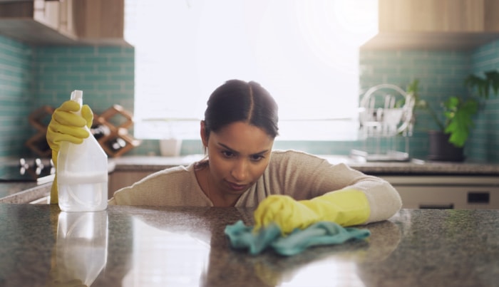 utilisations du peroxyde d'hydrogène - une femme regardant attentivement tout en nettoyant le granit