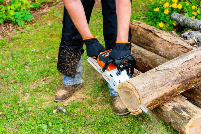 Une personne utilise la tronçonneuse électrique Stihl MSA pour scier l'extrémité d'une bûche