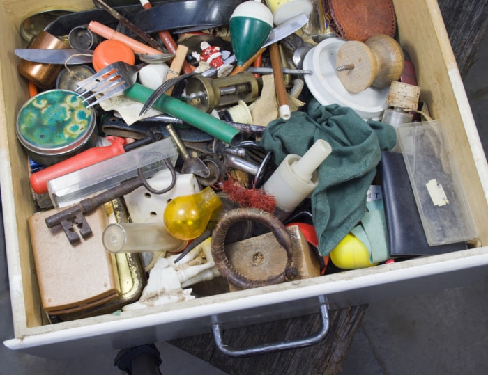 Un tiroir à bric-à-brac rempli d'articles ménagers éclectiques.