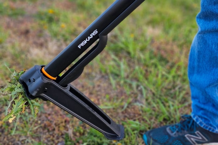 L'arracheuse de mauvaises herbes debout Fiskars s'enfonce dans le sol pendant les tests.