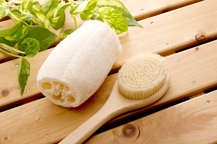 loofah sur surface en bois avec brosse de bain