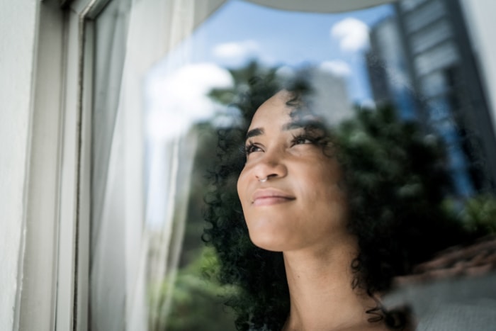 Femme regardant par la fenêtre