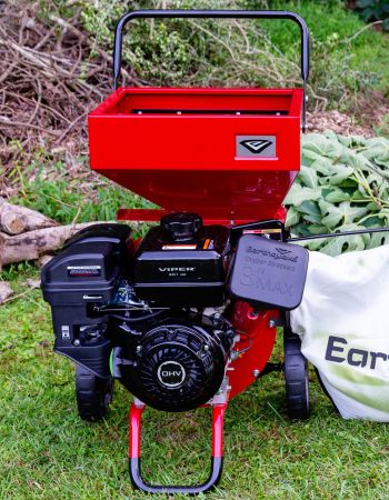 Déchiqueteuse de bois Red Earthquake K33 sur l'herbe à côté d'un sac de copeaux de boisDéchiqueteuse de bois Red Earthquake K33 sur l'herbe à côté d'un sac de copeaux de bois