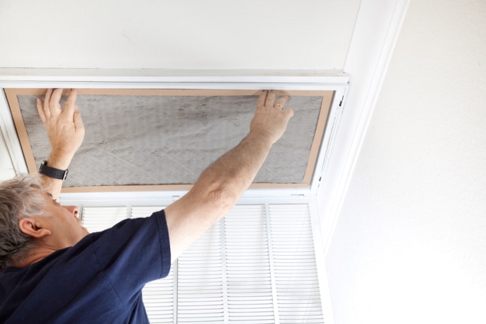 Homme changeant le filtre à air