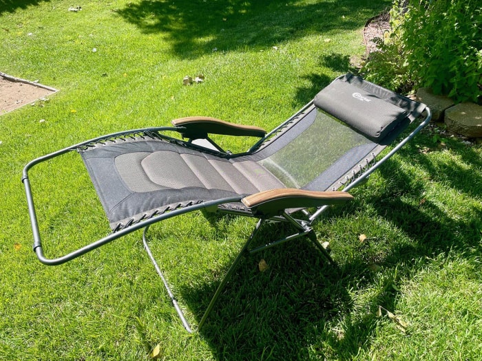 Chaise noire à gravité zéro allongée sur une pelouse