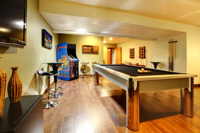 Salle de jeux amusante à l'intérieur de la maison. Pièce au sous-sol sans fenêtres avec table de billard, télévision, jeux.