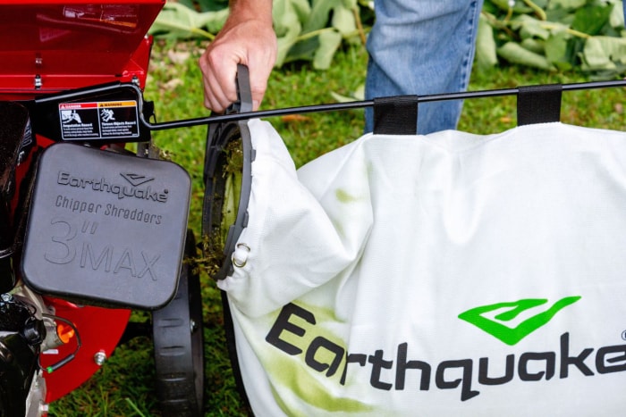 Personne retirant un sac plein de copeaux de bois de la déchiqueteuse Earthquake K33