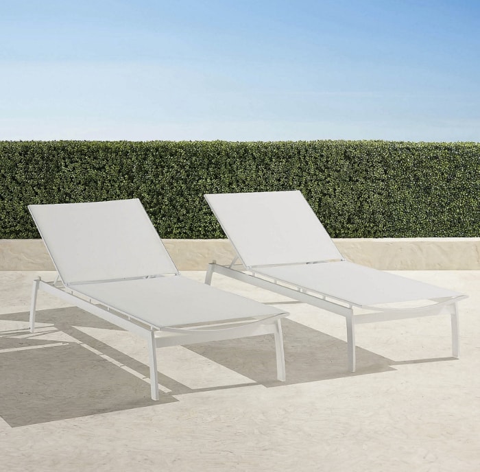 Deux chaises longues en aluminium blanc sur le patio.