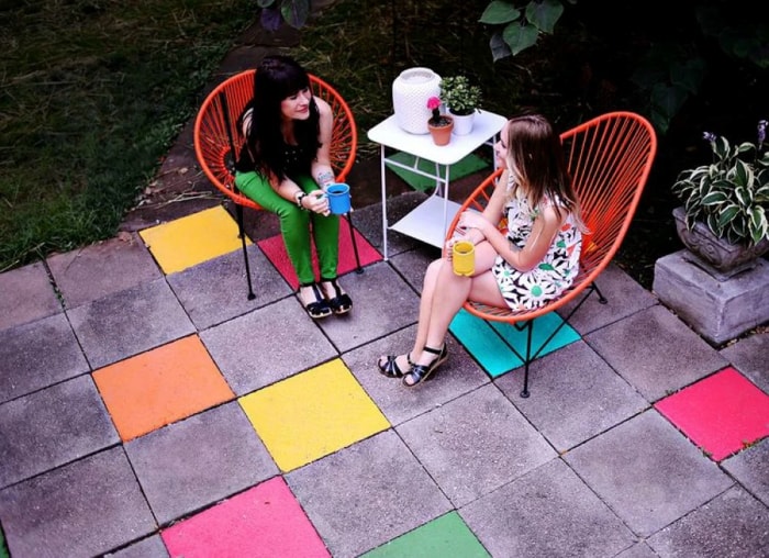 Patio arrière en béton avec carrés colorés.