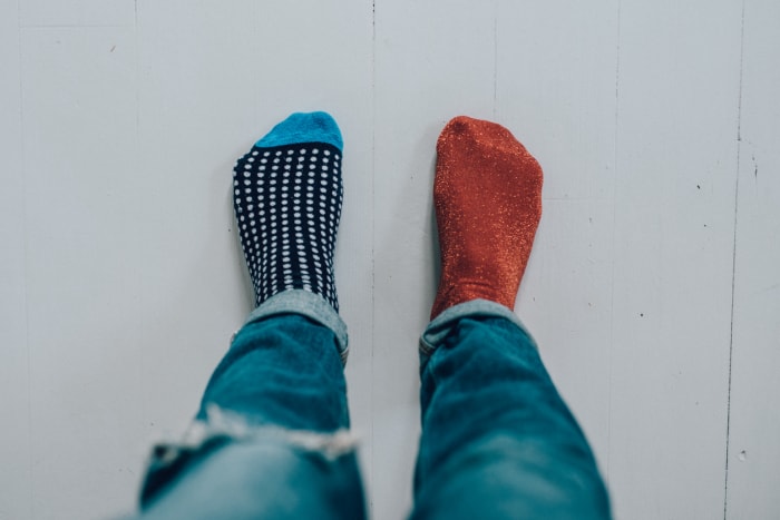 Point de vue des pieds d'une personne portant un jean et deux chaussettes différentes.