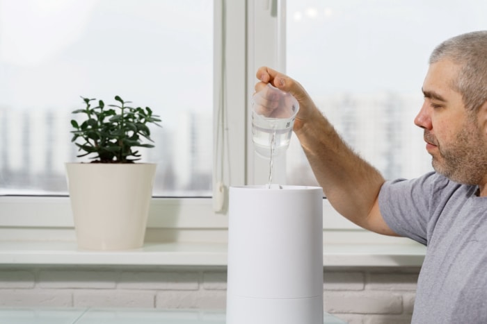 utilisations du peroxyde d'hydrogène - homme versant une solution d'eau dans un humidificateur