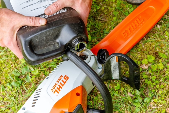 Quelqu'un ajoute de l'huile à la tronçonneuse électrique Stihl MSA