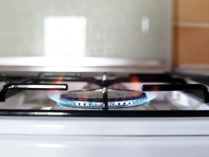 Un brûleur de cuisinière à gaz près d'un mur peint.