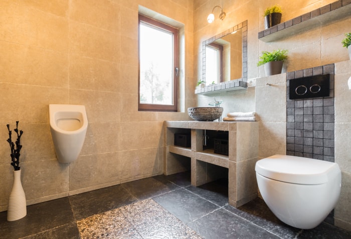 salle de bain en granit et pierre calcaire avec des équipements modernes et un urinoir