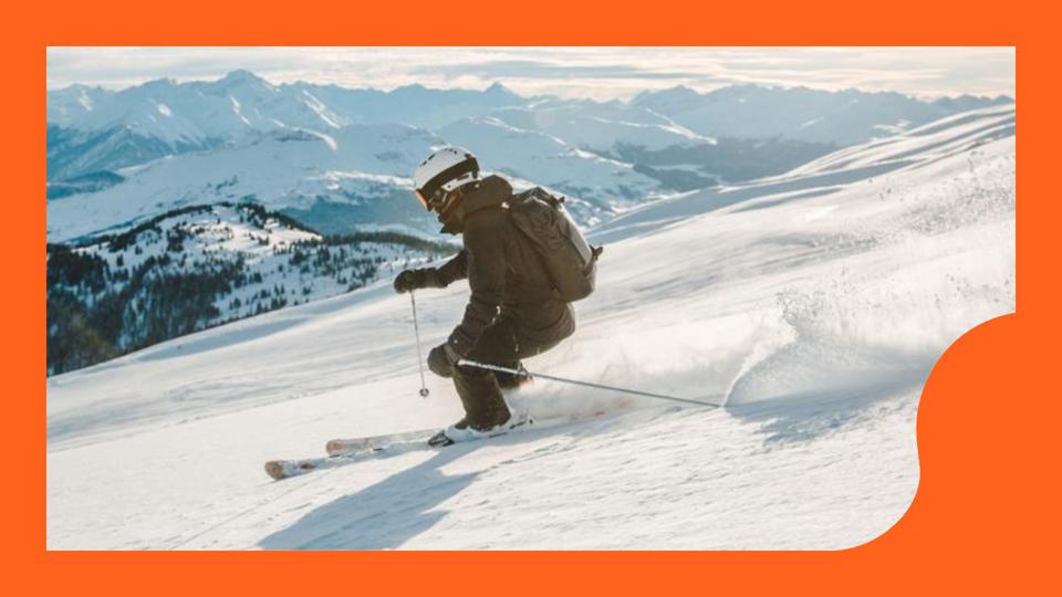 A woman skiing down a mountain while wearing a ski backpack.