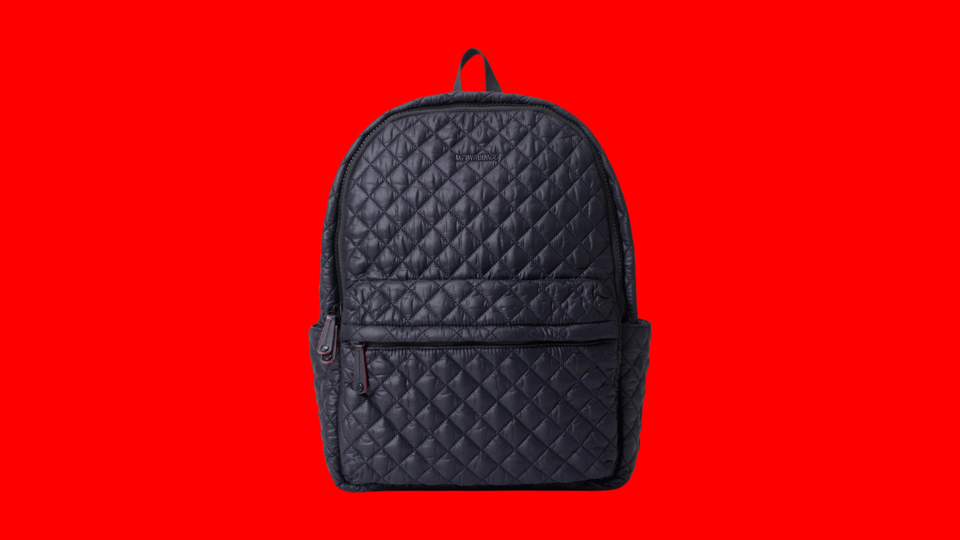 The MZ Wallace Metro Backpack Deluxe on a red background.