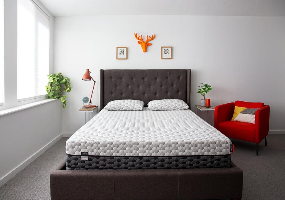 The Layla mattress on a gray bed frame in a white room.