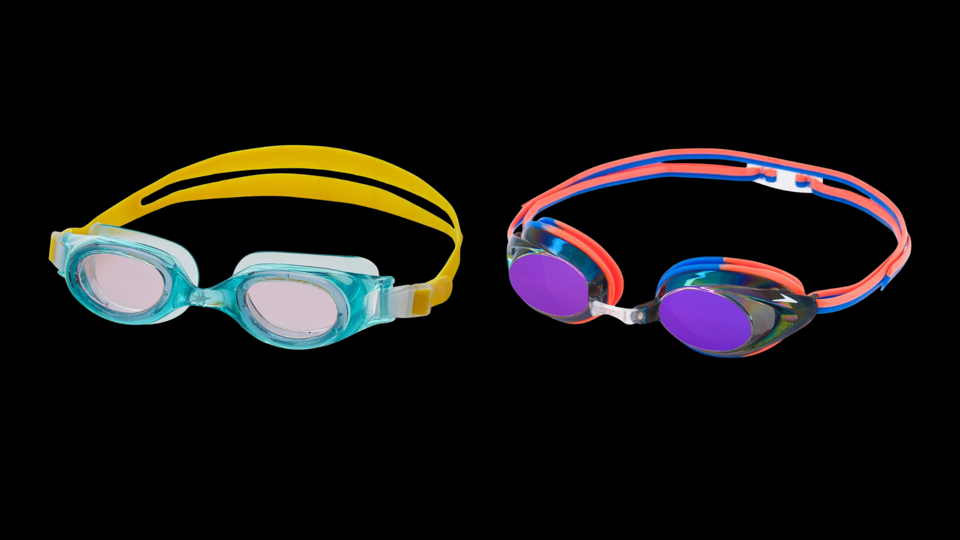 Two brightly colored pairs of childrens swim goggles on a black background