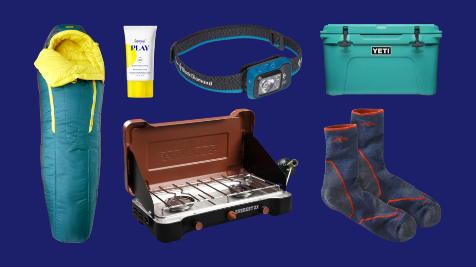 A sleeping bag, headlamp, cooler, sunscreen, stove and socks on a dark blue background