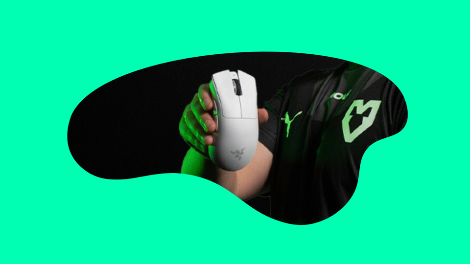 A photo of a mouse being held up by a esports gamer.