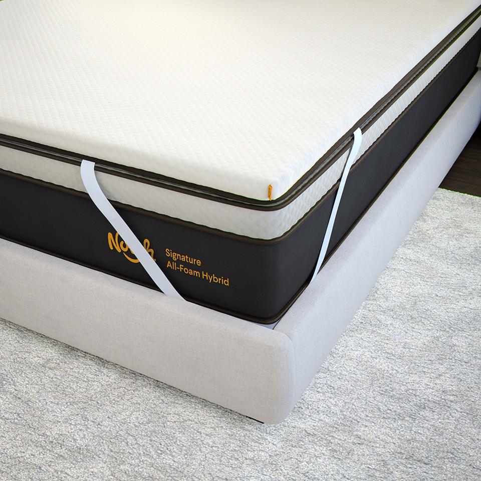 The Nolah Mattress Topper on top of a Nolah mattress and white bed frame. 