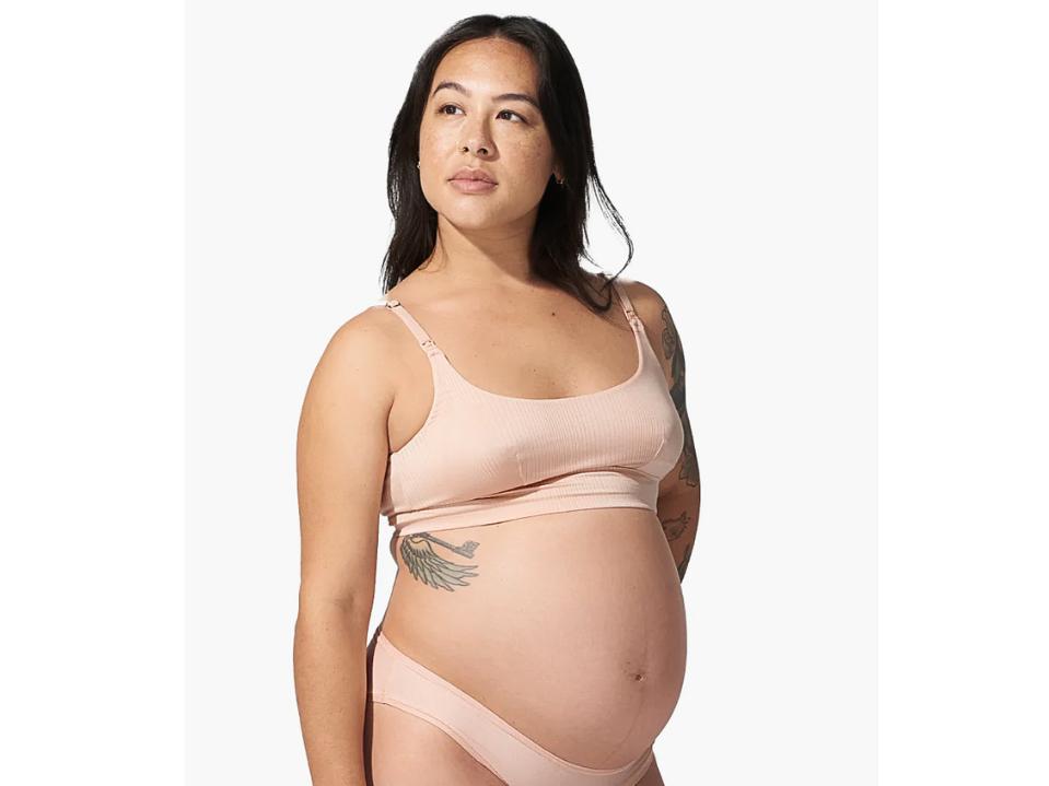 woman wearing light pink bodily The Everything Bra standing against beige background