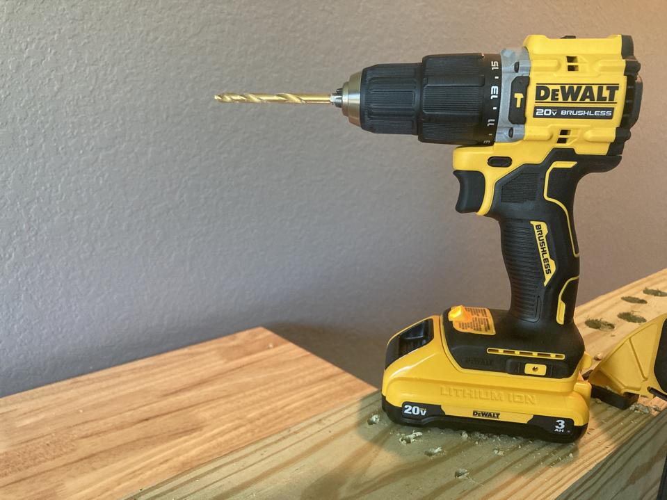 The DeWalt 20V Max Cordless Hammer Drill with an illuminated LED light on top of lumber 