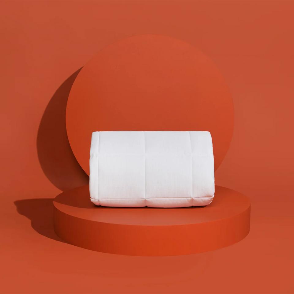 The Slumber Cloud Performance Mattress Pad against a bright orange background.