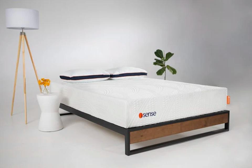 iSense Classic Mattress on a rustic metal and wood frame in a white room.