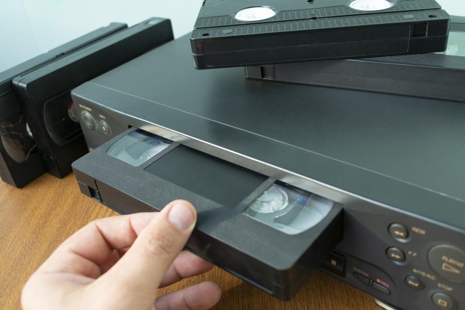 insert a videotape into a tape recorder