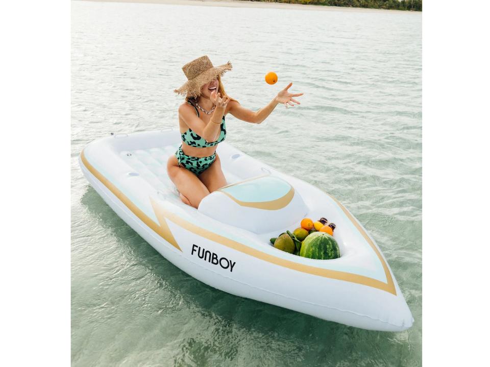 woman ob FUNBOY Giant Inflatable Yacht Speed Boat Pool Float on water with fruits