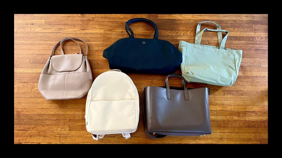 Five work bags against a wooden floor