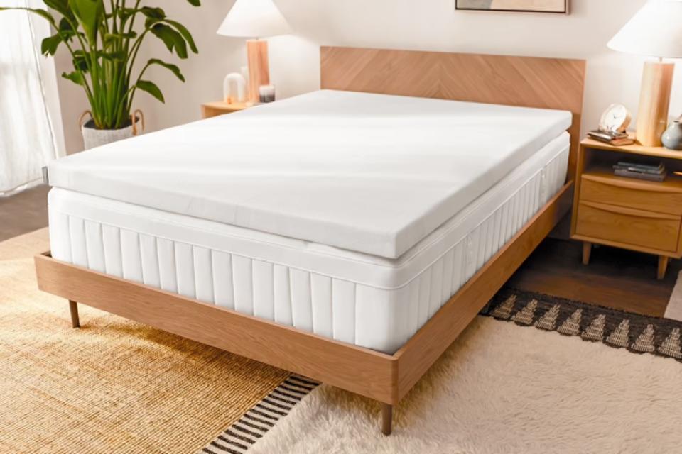 The Tempur-Pedic Tempur-Adapt mattress topper on a mattress on a bed frame in a bedroom