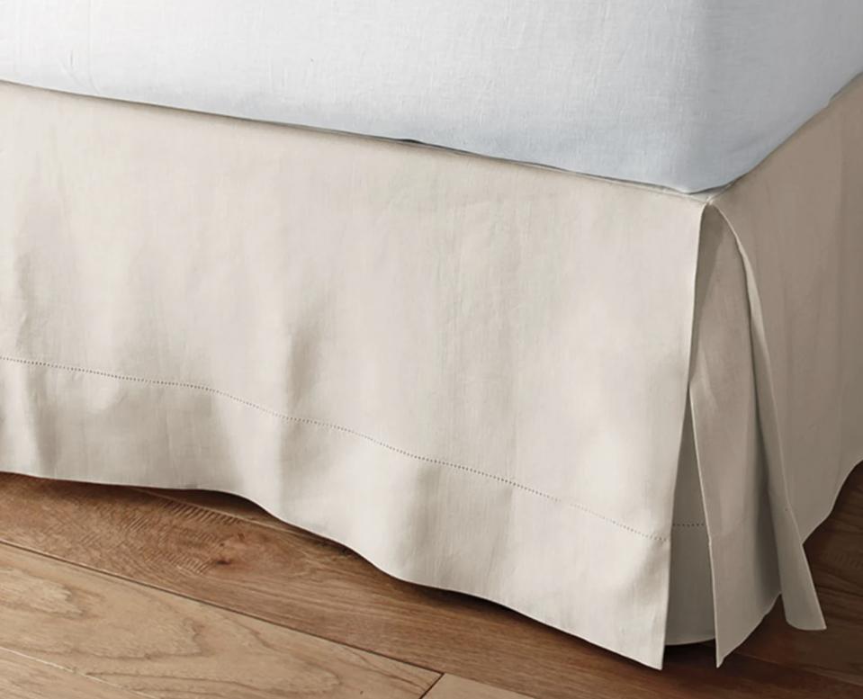 Legends Hotel Relaxed Linen Bed Skirt in beige on a bed frame over a wooden floor