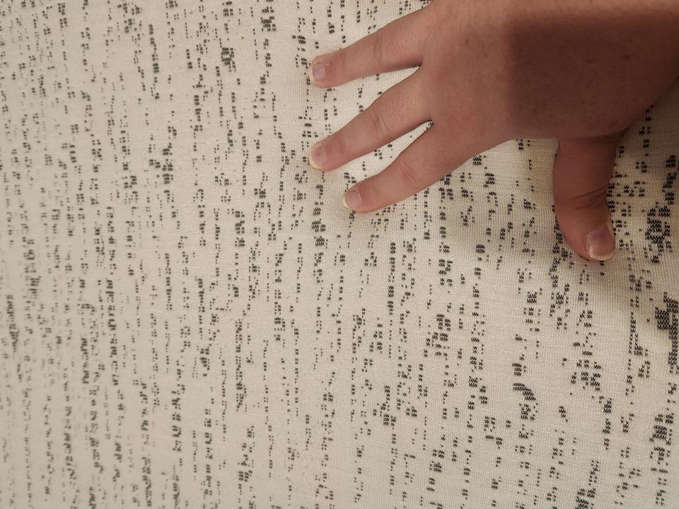 A woman's hand touching the top of a Viscosoft Mattress Topper. 