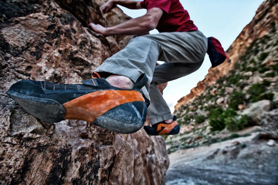 Man rock climbing on sandstone boulder, Grand Junction, Colorado, USA