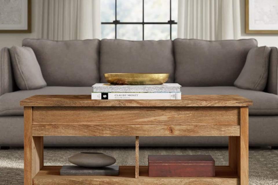 The Mccaslin Coffee Table in a living room, styled with coffee table books on top