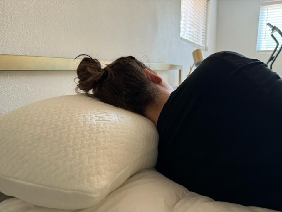 The author sleeping on her side on the Ontel pillow facing away from the camera