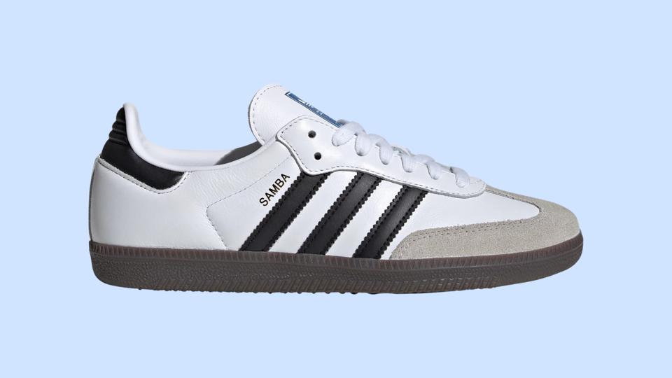 A white, black and gray Adidas Samba sneaker on a light blue background