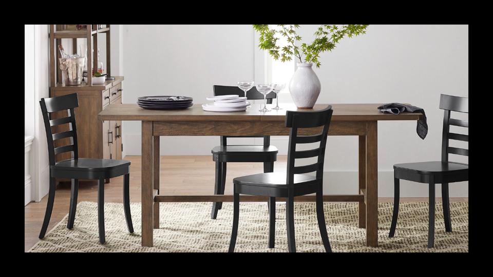 Pottery Barn's Mateo Extending Dining Table with chairs and a plant.