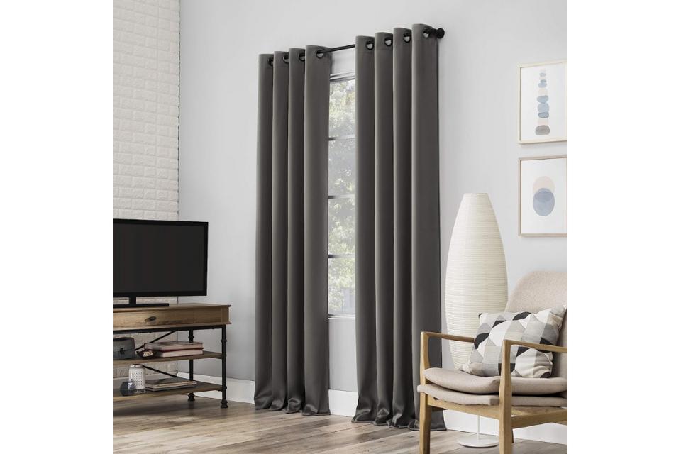 Sun Zero Nordic Theater-Grade Blackout Grommet Curtain Panel Pair hanging on a tall window