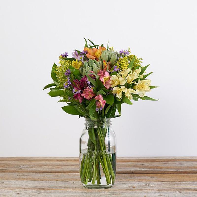 alstroemeria solidago aster succulent bouquet in water bouqs clear jar wood surface white background